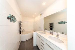 a bathroom with two sinks and a tub and a mirror at Il nido appartamento nel cuore del centro storico in Luino +7 photos