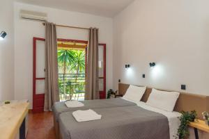 a bedroom with two beds and a large window at Calypso Resort Kavos in Kavos +75 photos