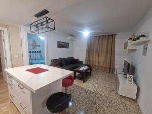 a kitchen and living room with a couch and a table at APARTAMENTOS EL ALCAZAR VIEJO (SAN BASILIO) in Córdoba