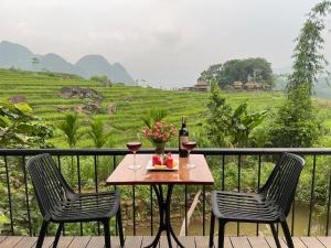 a table with two glasses of wine on a balcony at Puluong Valley Home in Thanh Hóa