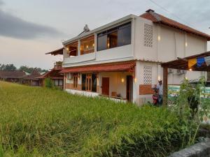 a house on top of a grassy hill at Alamanda Family Villas, Pool & Local Tours in Yogyakarta
