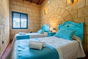 a bedroom with two beds with blue sheets at Casa Rural Carmo in Carmona +37 photos