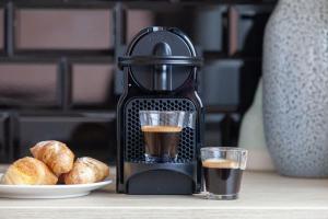 a coffee maker with a glass of coffee and a plate of bread at Welldone Sierpes Boutique in Seville