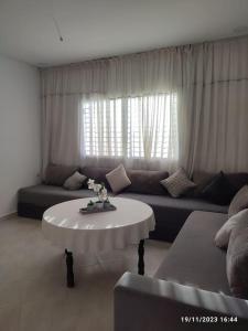 a living room with a couch and a table at appartement bien située in Saidia 