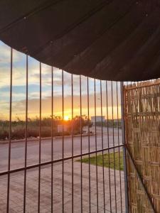 a view of the sunset seen through a metal fence at appartement bien située in Saidia 