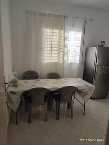 a kitchen with a table with chairs and a refrigerator at appartement bien située in Saidia 