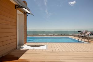 een zwembad met uitzicht op het strand bij Hotel Monaco in Caorle