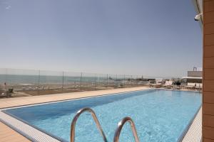 uma piscina com vista para a praia em Hotel Monaco em Caorle