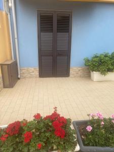 ein blaues Gebäude mit zwei Blumen vor einer Tür in der Unterkunft Hotel San Martino in Cassibile