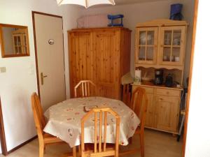 a dining room with a table and chairs and a kitchen at Appartement face à la montagne in Abondance