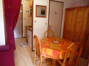 a kitchen with a table and chairs in a room at Appartement face à la montagne in Abondance