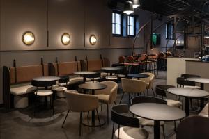 una habitación con mesas y sillas y un bar en Mercure Liege City Centre en Lieja