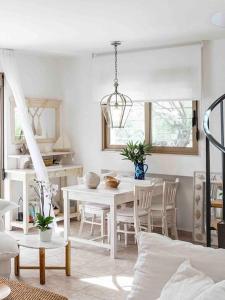 una sala da pranzo bianca con tavolo e sedie di Stylish Pool Villa Konstantinidis Complex a Hanioti