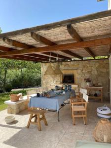 un patio con tavolo e sedie e un muro di pietra di Stylish Pool Villa Konstantinidis Complex a Hanioti