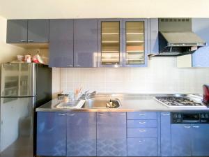una cocina con armarios azules y fregadero en hostelkochi TAO YASU - Vacation STAY 82868v en Konan