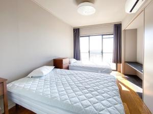 a bedroom with two beds and a window at hostelkochi TAO YASU - Vacation STAY 82868v in Konan