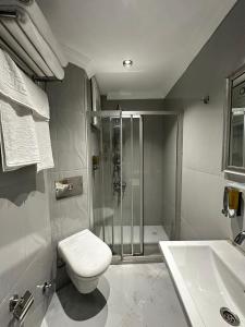 a bathroom with a shower and a toilet and a sink at New Hotel Harbiye in Istanbul +93 photos