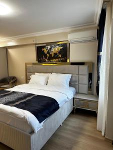 a bedroom with a large bed and a painting on the wall at New Hotel Harbiye in Istanbul