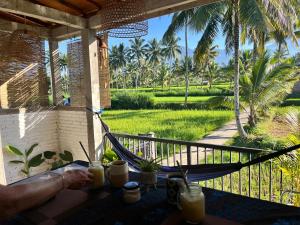 特特巴图MyHome - Lombok的门廊上的吊床,享有花园景色