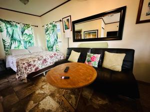 een woonkamer met een bank en een tafel bij Hawaiian Ohana Home in Hilo