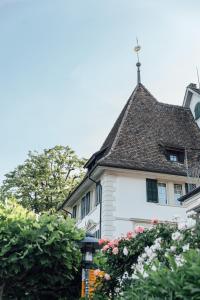 uma casa branca com uma cruz no telhado em Seehotel Sonne em Küsnacht