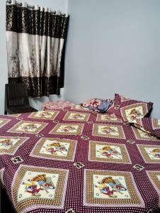 ein Bett mit einer Decke darüber in der Unterkunft Tandon Lodge in Varanasi