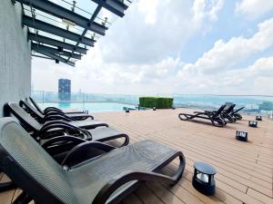 a row of chaise lounge chairs sitting on a patio at Duplex Eko Cheras Kuala Lumpur City Center Tun Razak Exchange Mall in Kuala Lumpur