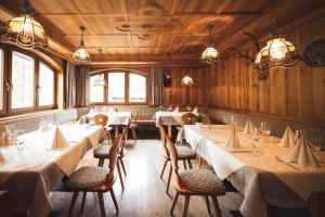 a dining room with tables and chairs and windows at Prissianerhof in Tesimo
