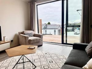 a living room with a couch and a chair and a table at Nice New 3 bedroom Townhouse U4 in Hamilton