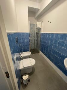 Hotel San Martino في كاسيبيلي: حمام من البلاط الأزرق مع مرحاضين ودش