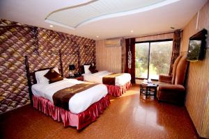 a hotel room with two beds and a television at Premier inn Mall Lahore in Lahore