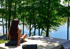 AntalgėGreen Harmony的坐在长凳上看着水面的女人