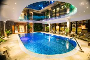 een groot zwembad in een huis met een plafond bij Hotel Foisorul cu Flori in Sinaia