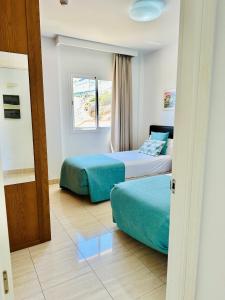 a hotel room with two beds and a window at Holiday Club Sol Amadores in Puerto Rico de Gran Canaria