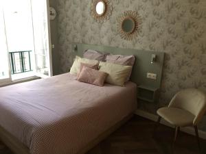 een slaapkamer met een bed met een stoel en een spiegel bij Central Station apartment in Nice