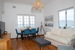 a living room with a white couch and a table at St James Mansions Apartment in Muizenberg