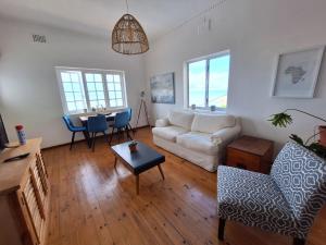 a living room with a couch and a table at St James Mansions Apartment in Muizenberg