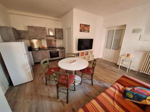 a living room with a table and chairs and a kitchen at Casa Elisa due passi dalla Torre pendente in Pisa
