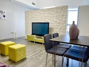 a living room with a television and a table and chairs at Fabulous Residential Private Apartment Upgraded Full Sea & Mangrove Views Abu Dhabi - Not Hotel - 1106 in Abu Dhabi