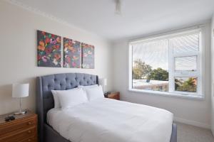 Un dormitorio con una cama grande y una ventana. en Apartment in the Heart of Sandy Bay, en Sandy Bay
