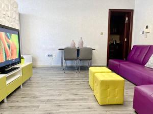 a living room with a purple couch and a table at Fabulous Residential Private Apartment Upgraded Full Sea & Mangrove Views Abu Dhabi - Not Hotel - 1106 in Abu Dhabi
