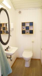 a bathroom with a toilet and a sink and a mirror at Sommerstua - Nes Camping in Moss