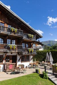 a building with tables and chairs in front of it at La Ferme du Golf in Megève