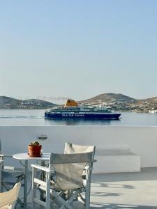 a cruise ship in the water with a table and chairs at Nostos Studios in Parikia