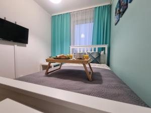 a bedroom with a bed with a table on it at Pokoje Częstochowa in Częstochowa