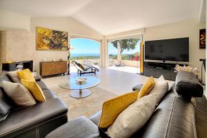 ein Wohnzimmer mit Couch und Fernseher in der Unterkunft FRGK " Villa de rêve avec vue mer sur le Cap d Antibes " in Vallauris