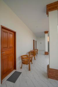 a row of chairs and a wooden door in a room at The Uma Canggu in Canggu