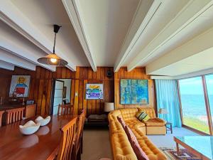 a living room with a couch and a table at Timber's Ocean House in Simonʼs Town