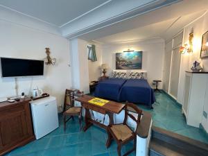 ein Hotelzimmer mit einem Bett, einem Tisch und einem Fernseher in der Unterkunft AUGUSTUS PARK Capri Center in Capri