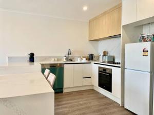 a kitchen with white cabinets and a white refrigerator at Nice 3 bedrooms Townhouse U5 in Hamilton +10 photos